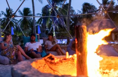 Image of people relaxing by a fire pit at dusk for a blog post on fire pit safety.