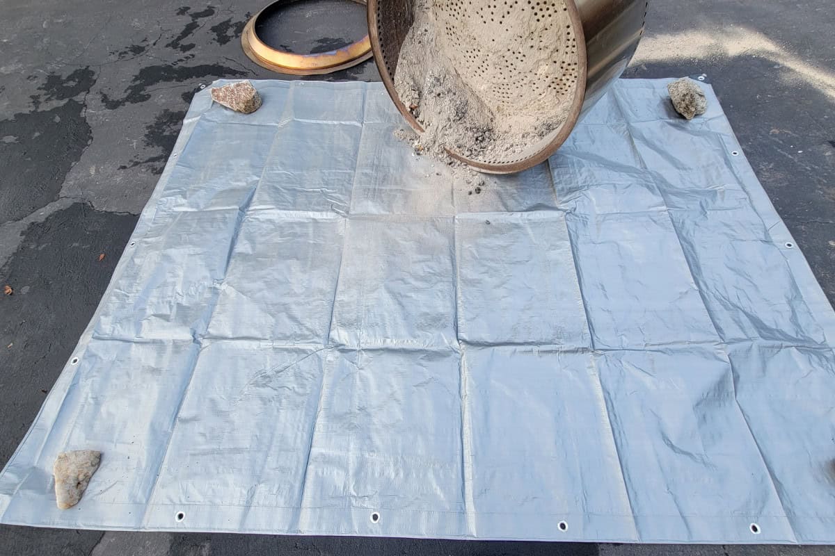 solo-stove-got-rained-on-maintenance Image of a fire pit having its ash removed.