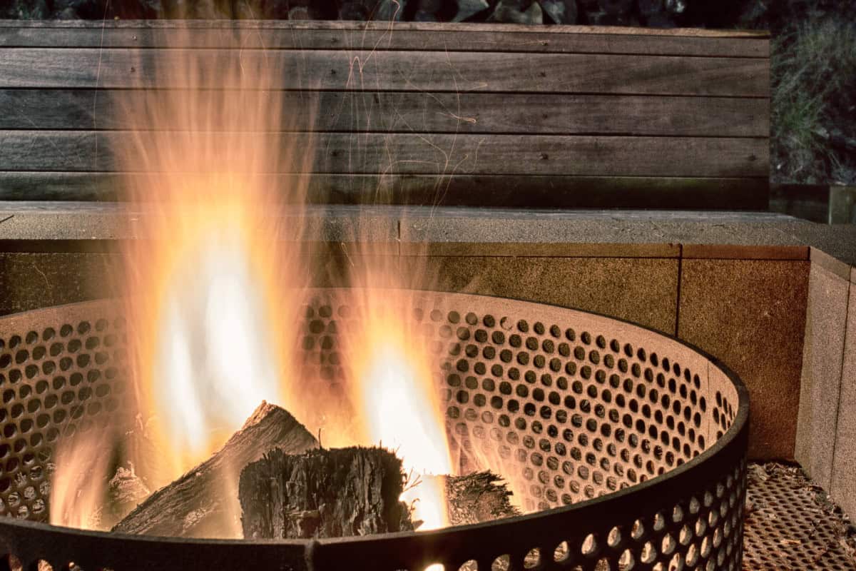 city-fire-pit-rules-closing Image of an urban fire pit burning at night for a guide covering city fire pit rules.