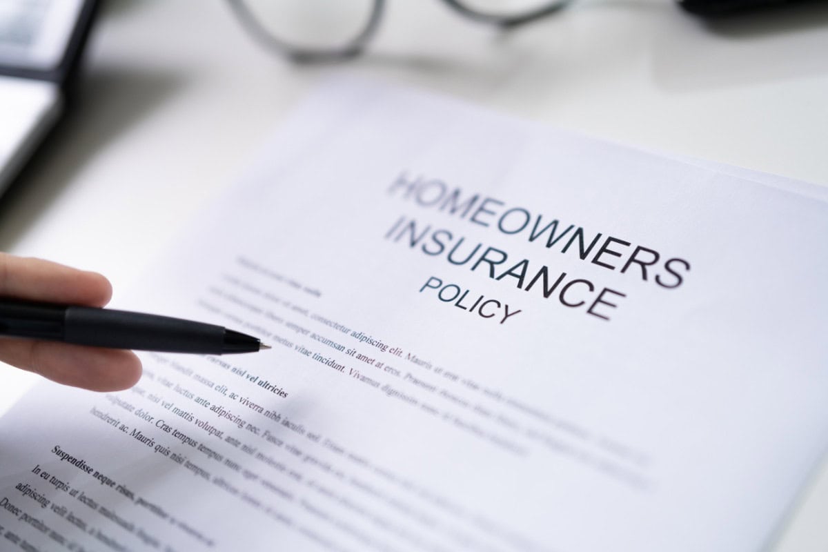 city-fire-pit-rules-faqs Image of a persion looking over the terms of a homeowners insurance policy.