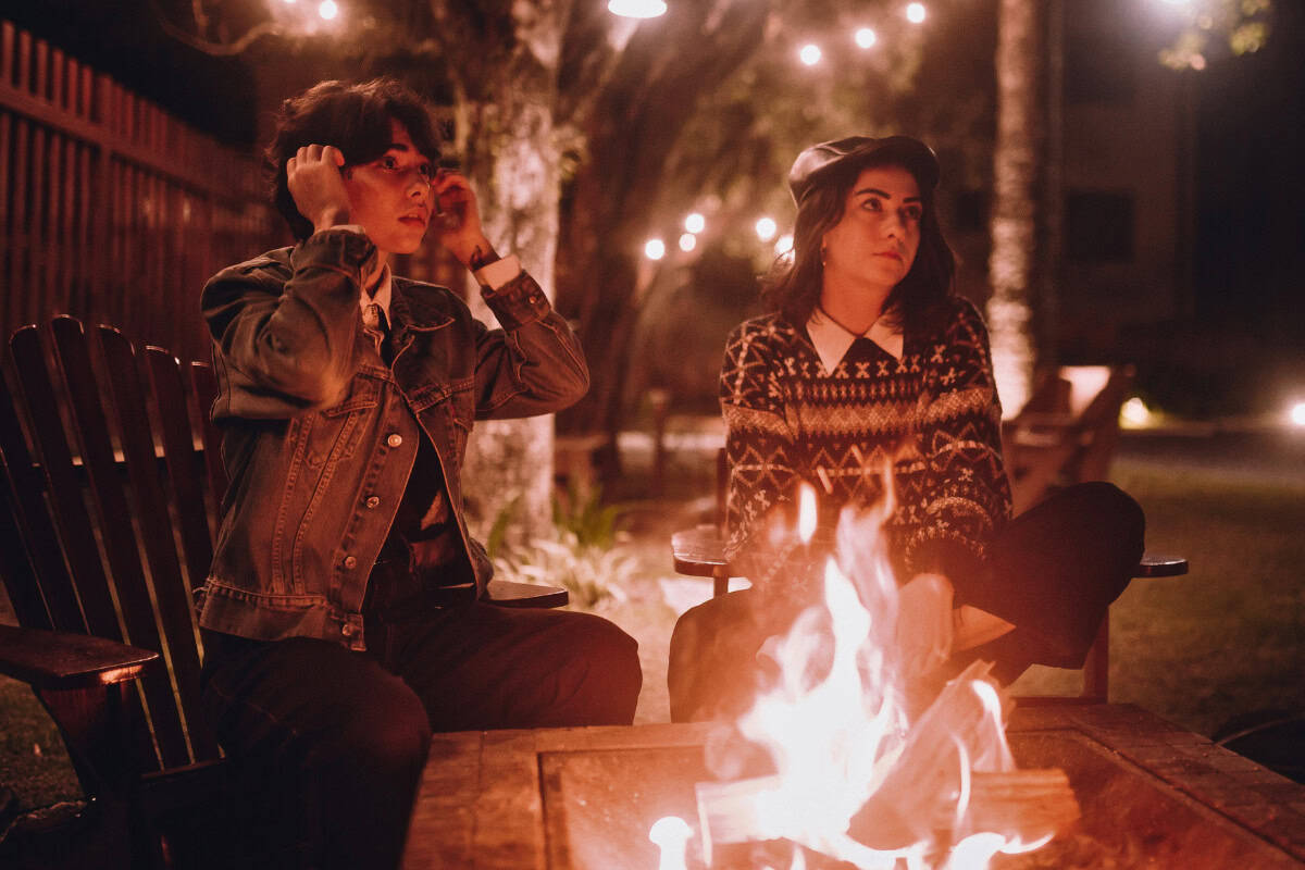 city-fire-pit-rules-main Image of two people sitting by a burning urban fire pit at night for a guide on urban fire pit rules.