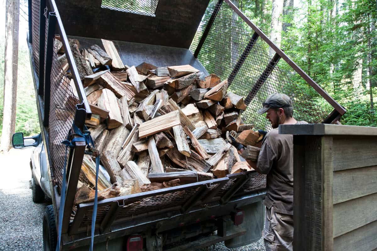 Local vs. Long-Distance Firewood Image of a man delivering a truckload of firewood.