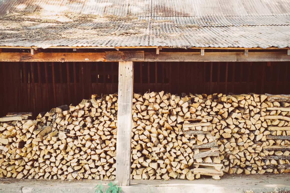 Storing Kiln Dried Firewood Image of firewood under a covered storage area.