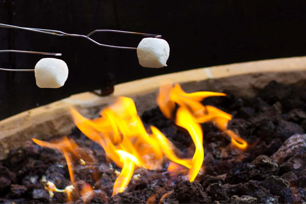 marshmallows-over-a-gas-fire-pit-tools Image of two marshmallows roasting over a flame.
