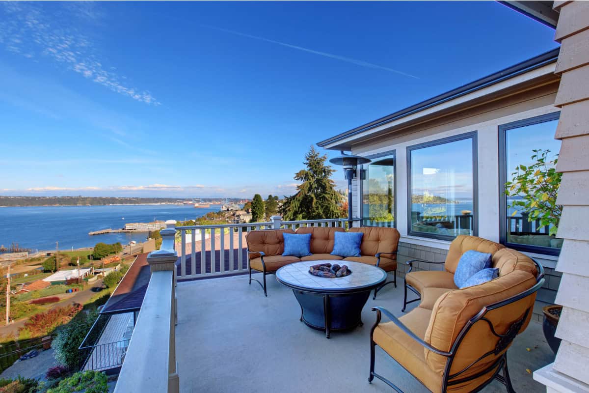 fire-pit-on-a-balcony-main Image of a tiled round propane fire pit on a seaside home's balcony.