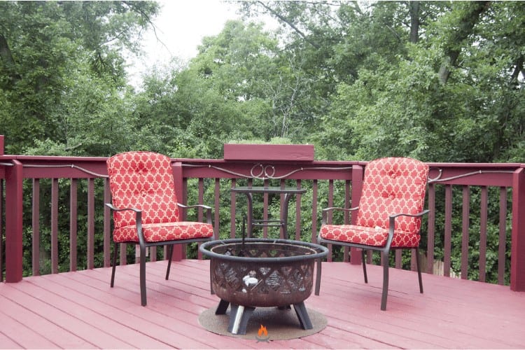 Image of a fire pit on a deck overlooking the woods