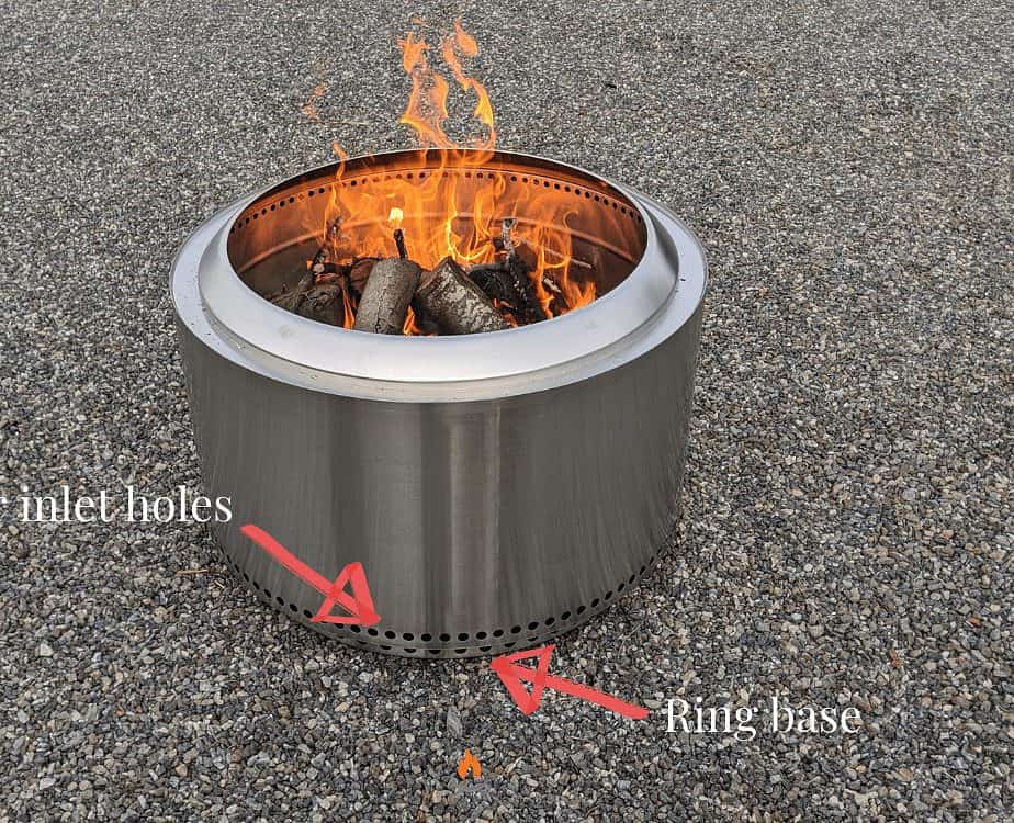Image of a burning Solo Stove fire pit on a stone driveway.