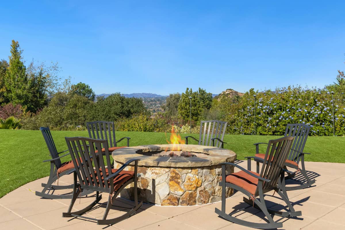 fire-pit-home-value-roi-main Image of a wood burning masonry fire pit in a backyard.
