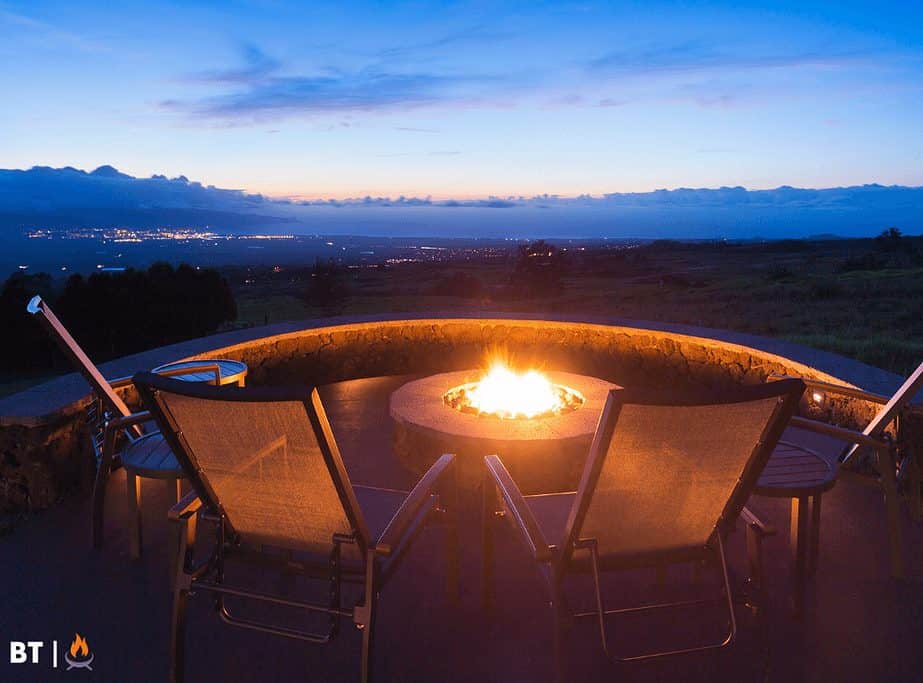 Image of a round stone fire pit overlooking a city skyline
