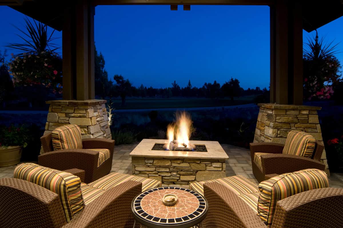 fire-pit-benefits-cozy-space Image of a fixed gas fire pit and four chairs on the corners.
