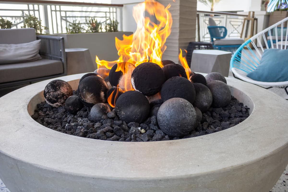 fire-pit-benefits-increase-property-value Image of a round gas fire pit with large round fire pit media added.