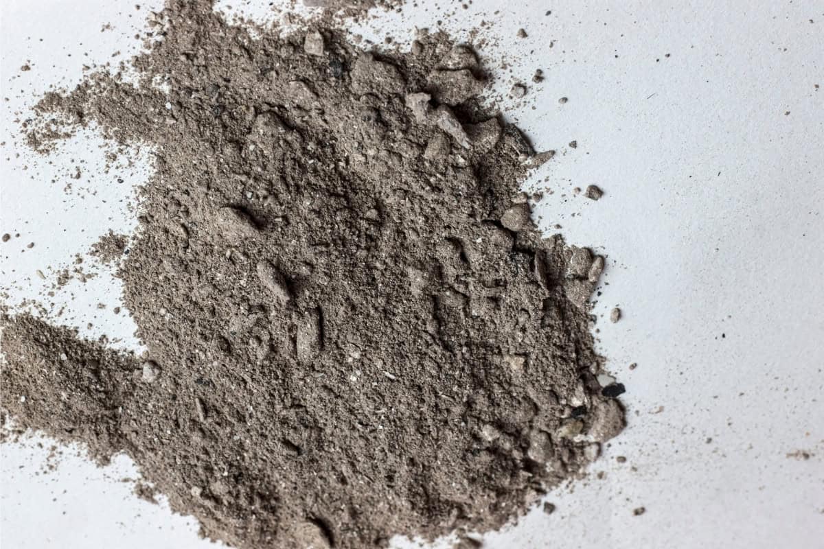 Image of spilled fire pit ash on a concrete floor.