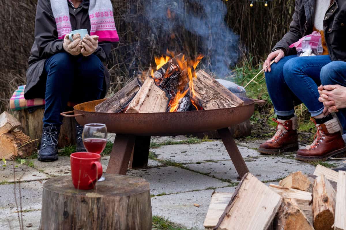 Image of three people around a fire pit on a chilly fall day.