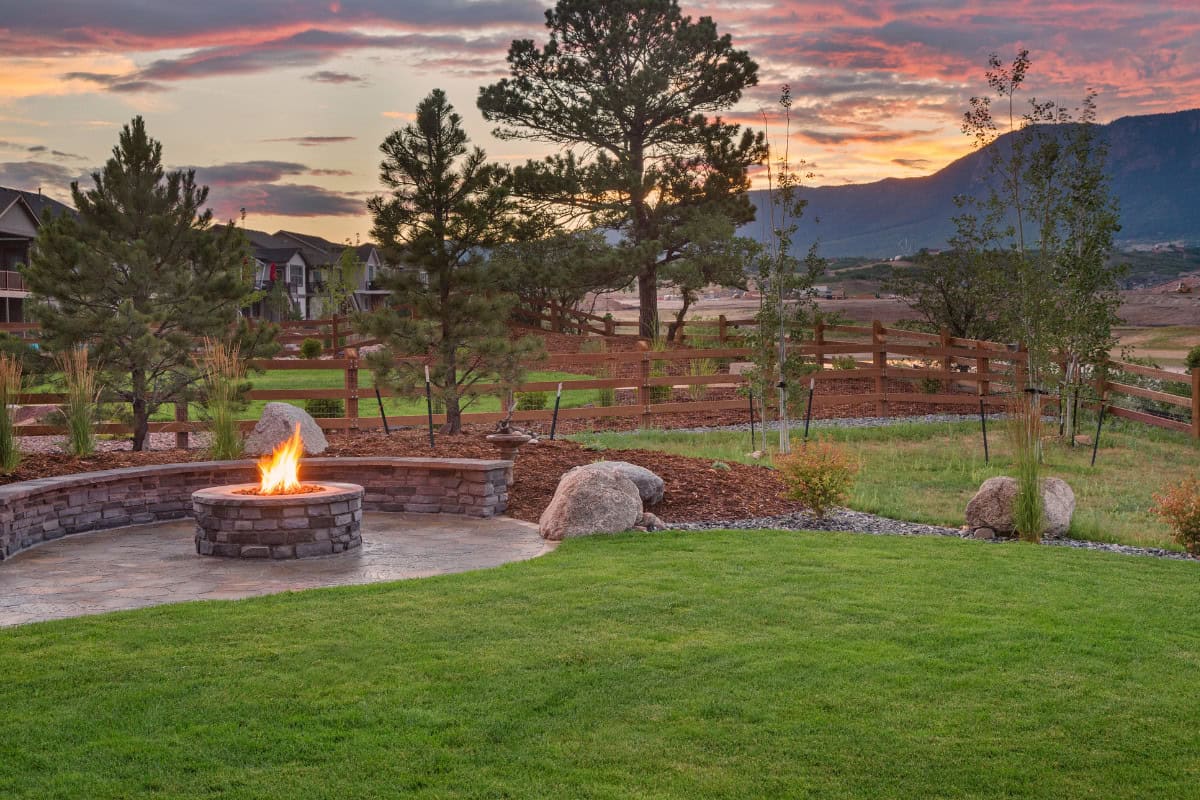 fire-pit-adhesives-closing Image of a yard with a block fire pit at the left of image.