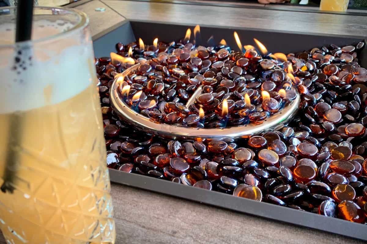 fire-pit-glass-what-is-it Image of amber colored fireglass in a square fire pit table.