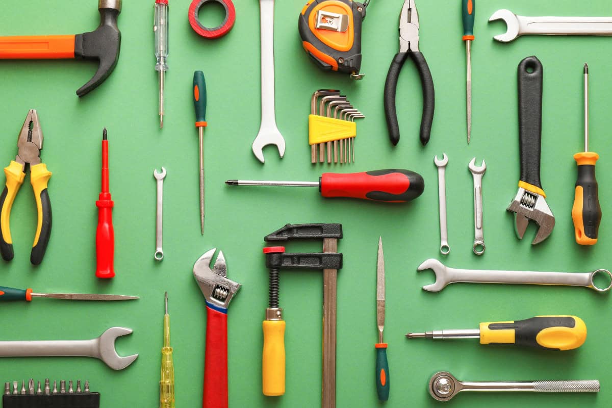 gas-fire-pit-whistles-professional-help Image of multiple hand tool types on a green background.