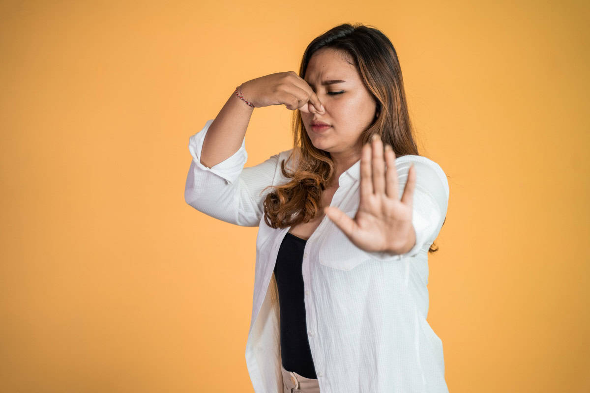 gas-fire-pit-whistles-safety Image of a woman holding her nose for a blog post about gas fire pit whistles.