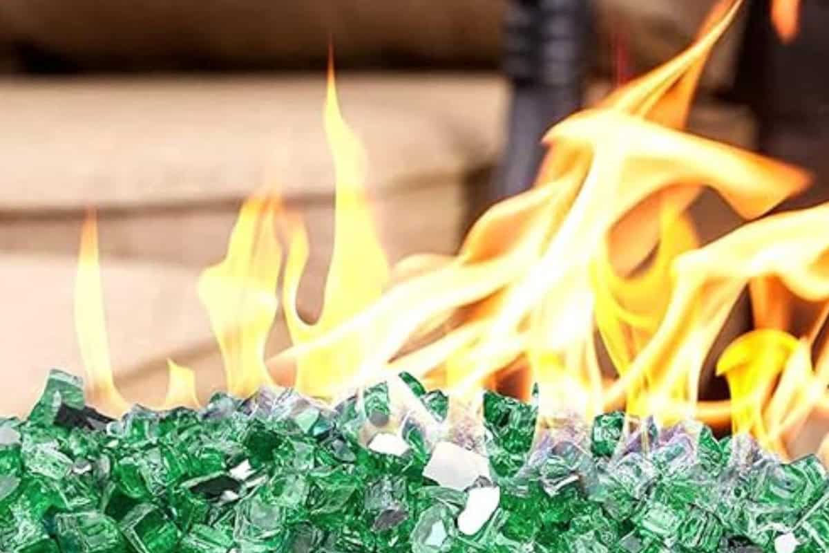 Fire Pit Glass FAQs Image of a lit fire pit with green fire glass for a blog post answering the question "how long does fire pit glass last?"