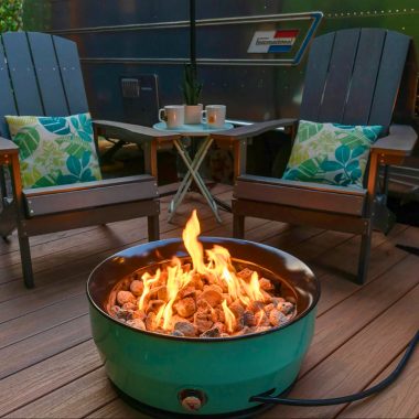 Image of a portable gas fire pit on composite decking for a blog post that answers the question, "how many fire pit btus do I need?"