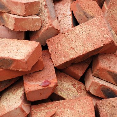 Image of a pile of clay bricks for a blog post discussing what bricks for a fire pit.