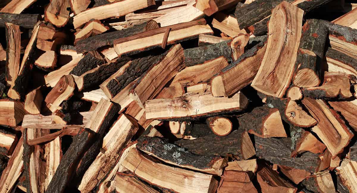 Image of a pile of freshly chopped firewood for a blog page with a firewood BTU chart.