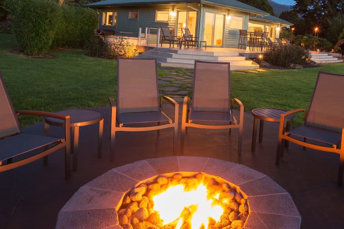 gas-fire-pits-provide-heat-closing Image of a fixed gas fire pit burning at dusk.
