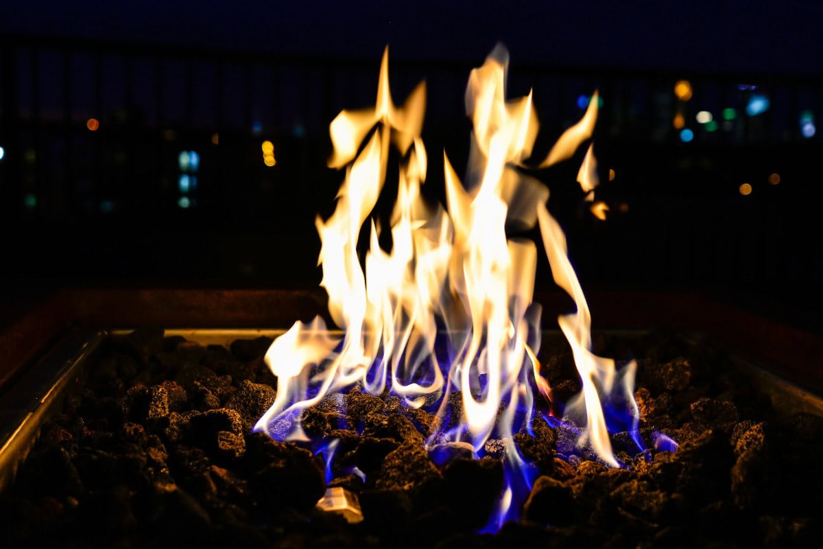 gas-fire-pits-provide-heat-factors Image of a square gas fire pit burning at night.