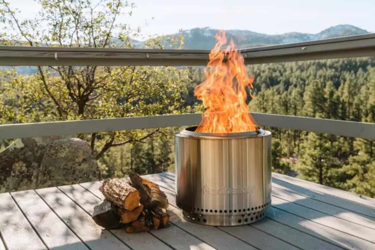 what-size-solo-stove-factors Image of a Solo Stove Bonfire burning on a deck with a mountain view.