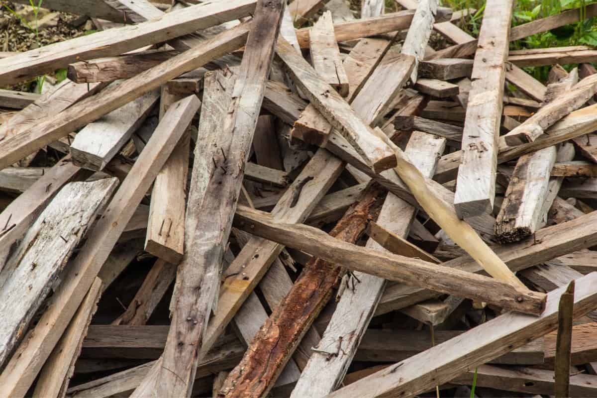 best-smelling-firewood-for-fire-pits-mistakes Image of a pile of used lumber with nails protruding.