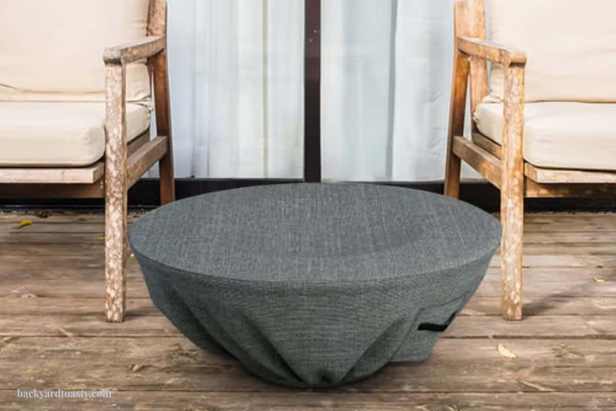 measure-for-a-fire-pit-cover-sizing Image of a fire pit bowl and chairs on a wood deck.