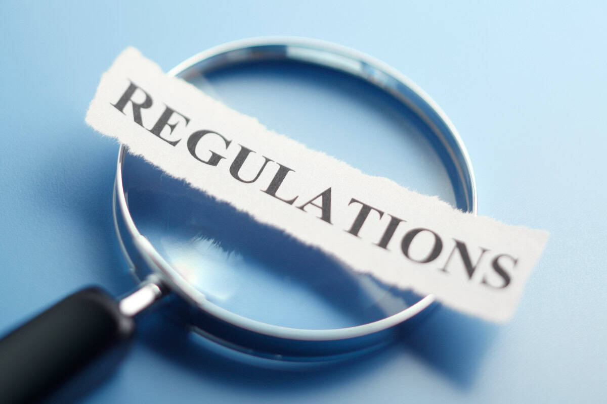 fire-pit-under-covered-patio-local-regs Regulations compliance concept with a magnifying glass emphasizing the word "Regulations" against a blue background.