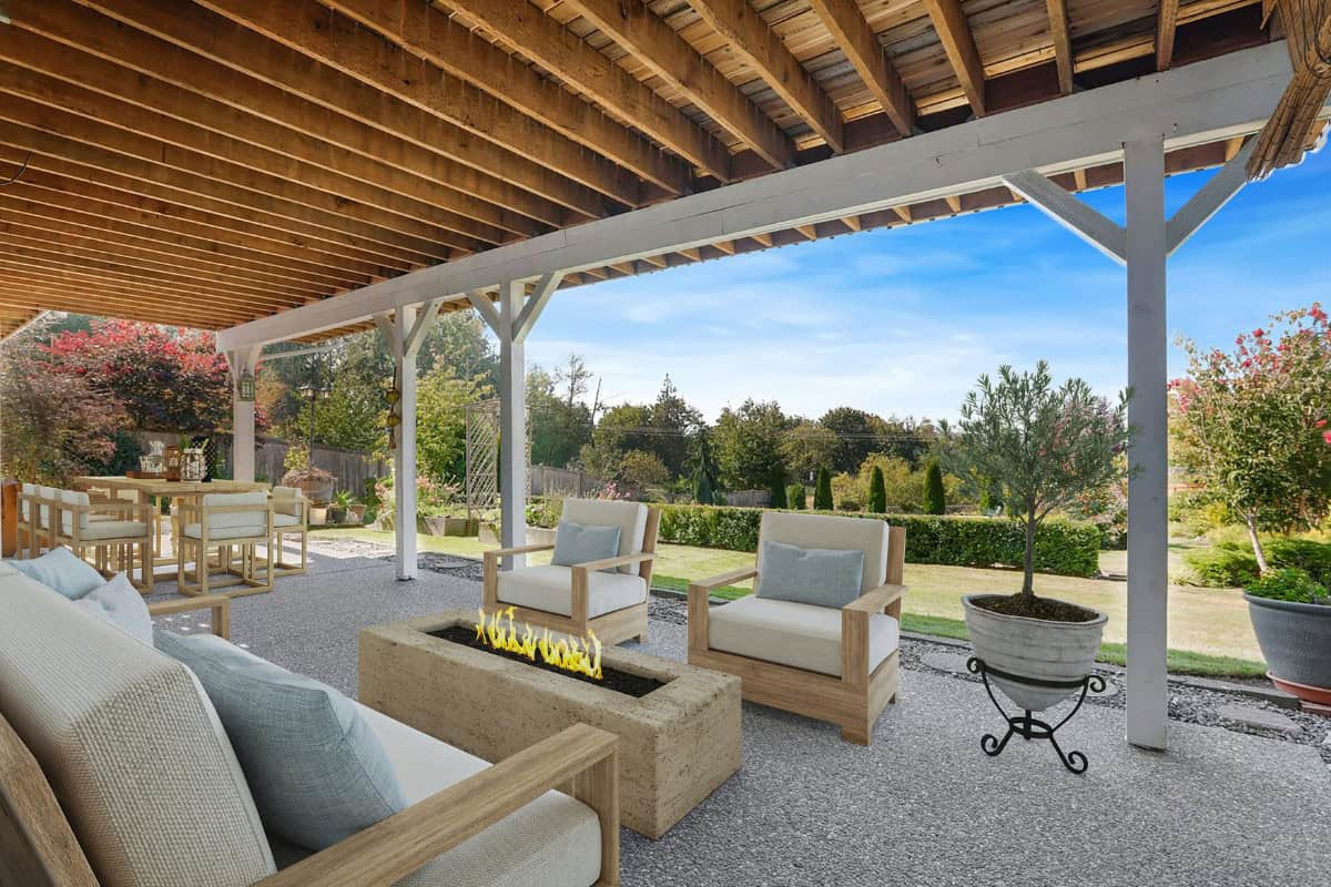 fire-pit-under-covered-patio-safety Cozy backyard patio with outdoor furniture, a modern fire pit, and lush garden landscape under a wooden pergola, perfect for outdoor relaxation and entertaining.