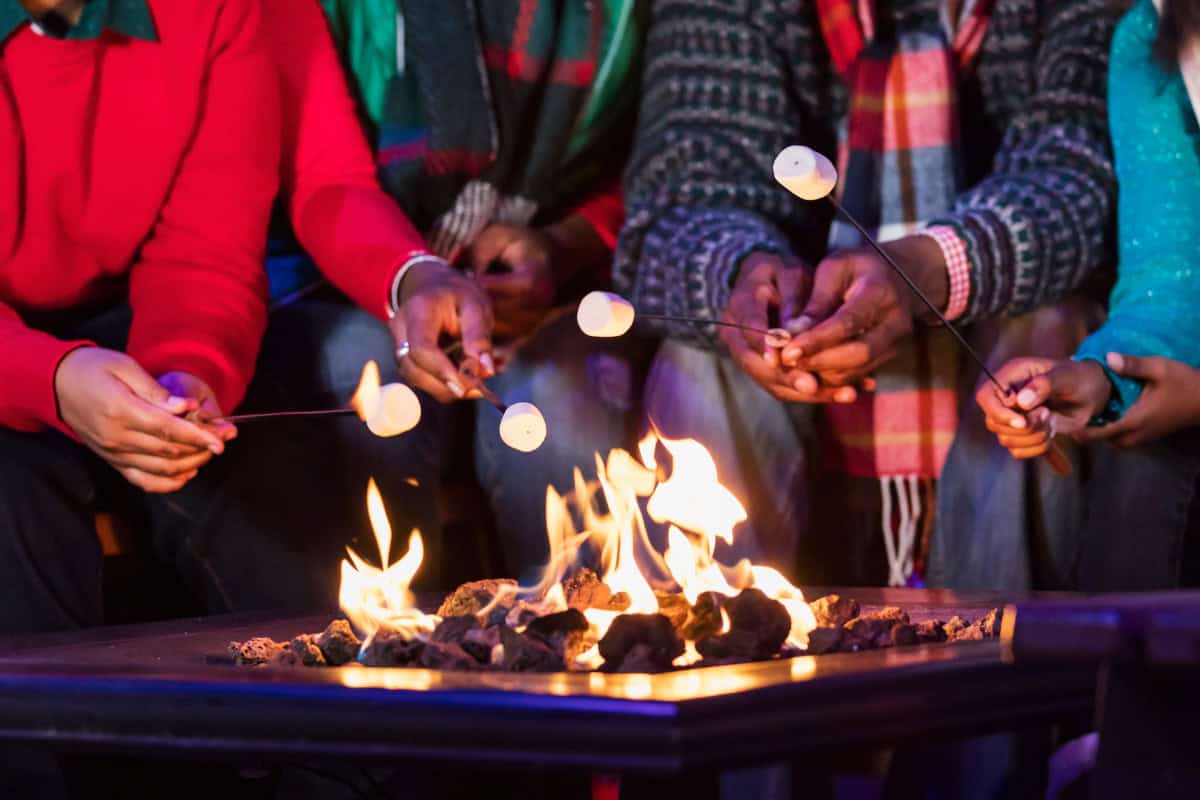gas-fire-pit-keeps-going-out-faqs Image of a family roasting marshmallows over a gas fire pit.