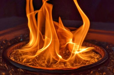 Image of a gas fire pit burner at nigh for an article covering why a gas fire pit keeps going out.