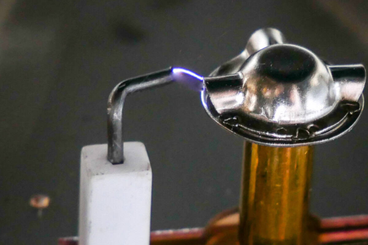 gas fire pit problems-components A propane torch igniting a small metal object for wood burning or pyrography art in a backyard setting.