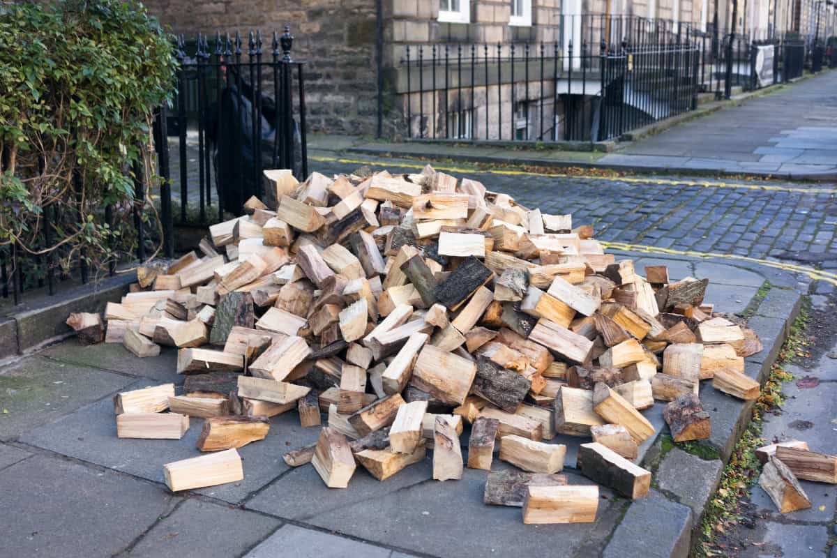 uk-firewood-prices-closing Image of a pile of firewood dumbed on a sidewalk in front of a home for a blog post on UK firewood prices.